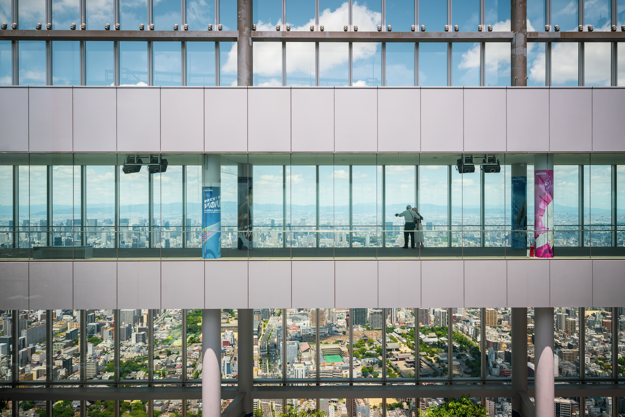 Building windows of a skyscraper with a couple looking out along the corridor